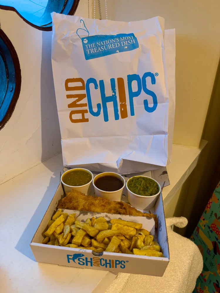 the tir a môr fish-and-chips photograph shows the meal with its takeaway wrapping and containers.
